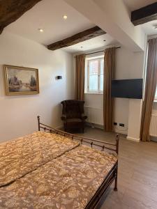 ein Schlafzimmer mit einem Bett und einem Stuhl in der Unterkunft Müllerstube im historischen Müllerhaus in Lübeck