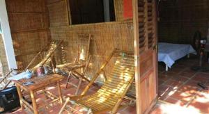 une chambre avec des chaises, une table et un lit dans l'établissement My Hoa Mekong Homestay, à Vĩnh Long