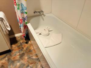 a bathroom with a bath tub with a towel at Awatea Park Motel in Palmerston North +15 photos