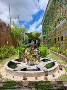 a garden with a fountain with statues in it at BC Lodge in Puerto Princesa City