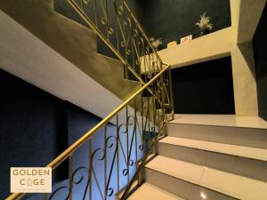 a staircase with a goldsteel railing in a house at Golden Cage Boutique Hostel in Denpasar