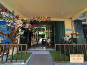 a building with a bunch of flowers in front of it at Golden Cage Boutique Hostel in Denpasar