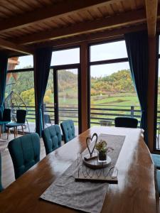 a dining room table with a view of the countryside at Cabana 3 Stejari Maramureș in Călineşti