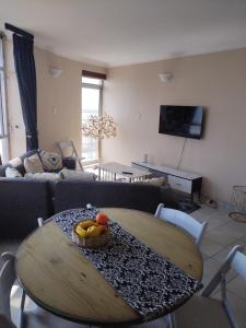 a living room with a table with a bowl of fruit on it at Tenbery1002 in Durban