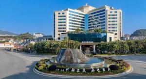 a large building with a fountain in the middle of a street at HELSTON HOTEL in Guancun