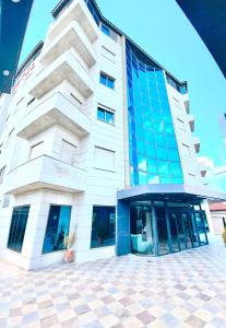 een groot wit gebouw met blauwe ramen aan een straat bij Panorama Amman Hotel in Amman