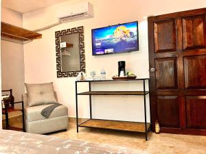 a bedroom with a chair and a tv on the wall at Hotel 305 in Parras de la Fuente +7 photos