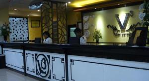 due persone in piedi al bancone di un ristorante di V3 Hotel a Surabaya