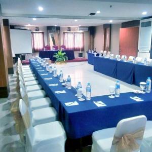 a long blue table with white chairs and bottles of water at Jelita Bandara Hotel Airport in Banjarbaru +55 photos