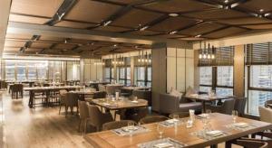 a dining room with tables and chairs and windows at Clear Lake Hotel in Shanwei