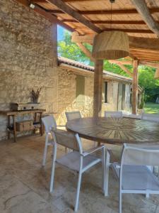 a dining room with a wooden table and chairs at La Maison Or Azur- Spa Jacuzzi- Terrasse - Vue Nature in Penne-dʼAgenais