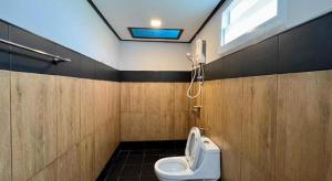 a bathroom with a toilet and a window at Zigzag Resort in Nakhon Phanom