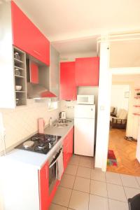 kuchnia z czerwonymi szafkami i białą lodówką w obiekcie Apartment Keglich w Zagrzebiu