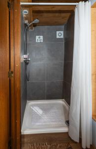 a bathroom with a shower with a shower curtain at Tiny House Les Jours Heureux Sejour nature pres de Dinant et des Lacs de l Eau d Heure in Villers-le-Gambon