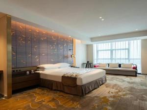 a bedroom with a large bed and a couch at Grand Metropark Hotel Chongqing in Chongqing +267 photos