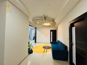 a living room with a blue couch and a table at Hotel Yatri in Gandhinagar