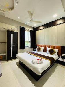 a bedroom with a large bed with a red ribbon on it at Hotel Yatri in Gandhinagar