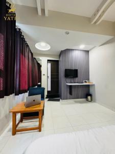 a living room with a desk and a laptop on a table at Hotel Yatri in Gandhinagar