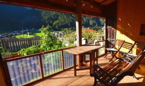 a porch with a wooden table and bench on a balcony at Brunnenhof Apartments in Pettneu am Arlberg