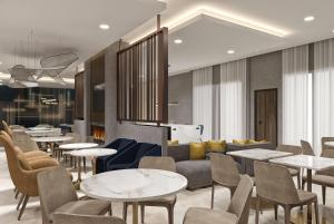 a restaurant with tables and chairs and a couch at La Quinta Inn & Suites by Wyndham Jackson in Jackson