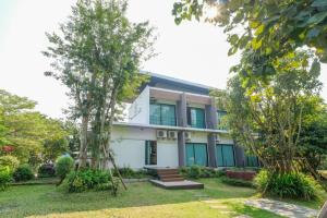 an exterior view of a house with trees at Haak Boutique Hotel in Chiang Mai