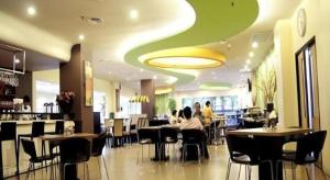 a restaurant with people sitting at tables in a cafeteria at Hotel Grand Anugerah in Bandar Lampung