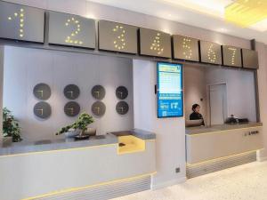 上海市にある7 Days Inn Shanghai Yichuan Roadのロビーのカウンターに座る者