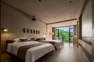 Ένα ή περισσότερα κρεβάτια σε δωμάτιο στο Qifeng Mountain Hidden Light Luxury Courtyard Hotel - Fenghuang Ancient City Nanhuamen