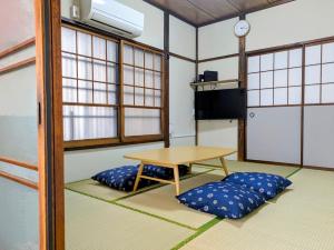 a room with a table and two pillows at サマサマアイル saMa-saMa Aisle in Odawara
