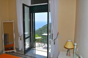a bedroom with a glass door leading to a balcony at villa verde sul mare in Vietri sul Mare