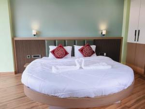 a large white bed with two white towels on it at Hotel Ratnadurga in Ratnagiri +21 photos