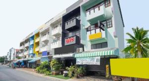 Un gran edificio con balcones coloridos en una calle. en OYO 723 Lamphun Hostel, en Lamphun