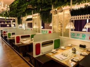 a restaurant with tables and chairs in a room at GreenTree Inn Wuhu Fanchang County Anding Road Hotel in Wuhu