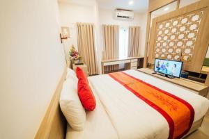 a bedroom with a large bed and a television at Green Hotel Da Nang in Da Nang