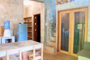 a kitchen with a refrigerator and a table in a room at Sea Esta Cruz Siargao in General Luna