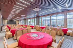 a conference room with red tables and chairs andwindows at Jolie Vue Boutique Hotel Sanjiang in Sanjiang +280 photos