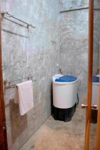 a bathroom with a blue and white toilet and towels at Sea Esta Cruz Siargao in General Luna