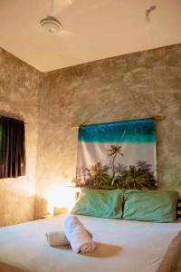 a bed with a towel laying on top of it at Sea Esta Cruz Siargao in General Luna