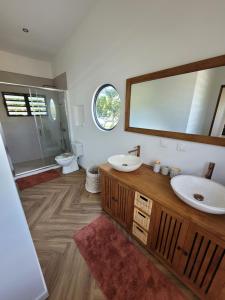 Un baño con dos lavabos y un espejo. en Villa Venus, en Mahina