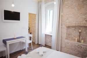 a room with a desk and a tv on a wall at Barone Room in Šibenik