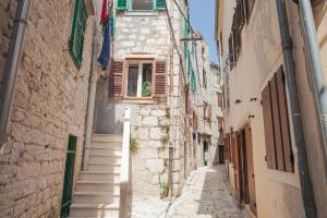 an alley in an old town with stairs at Barone Room in Šibenik