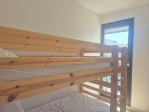 a wooden bunk bed in a room with a window at Appartement 2 pièces CAP D'AGDE CT865-2113 in Cap d'Agde
