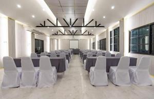 una habitación con hileras de mesas y sillas blancas en KS HOTEL, en Chiang Rai 104 fotos más