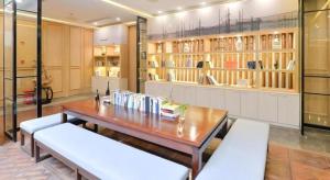 南通市にあるAtour Hotel Nantong Langshan Scenic Areaのテーブル、ベンチ、棚が備わる部屋