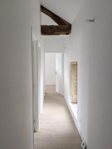 an empty hallway with white walls and a wooden floor at La halte caladoise in Gleizé