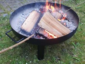 a grill with two logs on it with fire at Beim FörschtnSchorsch in Königsfeld