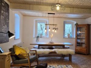 a living room with a table and chairs and windows at Beim FörschtnSchorsch in Königsfeld