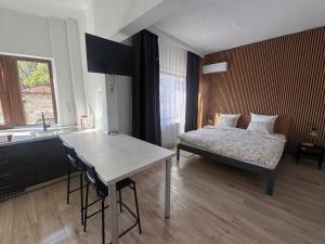 a bedroom with a bed and a table and a kitchen at AT Modern Boutique in Bucharest