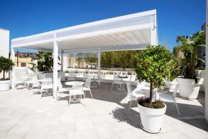 - un pavillon blanc avec des tables et des chaises sur la terrasse dans l'établissement Eunice Bed and Breakfast, à San Vito Lo Capo