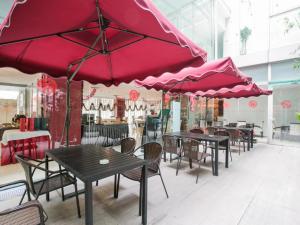 a group of tables and chairs with pink umbrellas at Hotel Kapok Wangfujing in Beijing